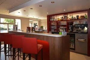 a bar with red bar stools in a restaurant at Campanile Reims Sud Bezannes in Reims