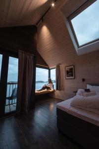 a bedroom with a bed and a large window at Hattvika Lodge in Ballstad +156 photos