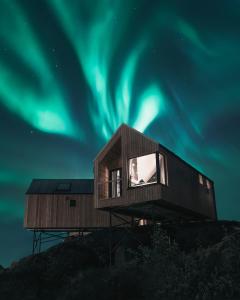 a house with the northern lights in the sky at Hattvika Lodge in Ballstad