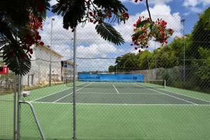 - un court de tennis avec filet dans l'établissement Résidence La Vieille Tour - ZENITUDE - Grand studio vue mer accès plage privative, au Gosier