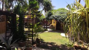 un jardin avec un portail et quelques plantes dans l'établissement Pousada Brisa & Soul, à Paracuru
