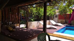 un patio con una cama y una piscina en Pousada Brisa & Soul, en Paracuru