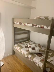 Ce lit se trouve dans un dortoir doté de 2 lits superposés et d'une lampe. dans l'établissement Les Pierres Blanches Mont Blanc, aux Contamines-Montjoie