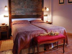 a bedroom with a large bed with a red seat at Hotel Casbas in Senegüé