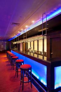 a bar with red bar stools in a room at Iberostar Selection Royal El Mansour in Mahdia