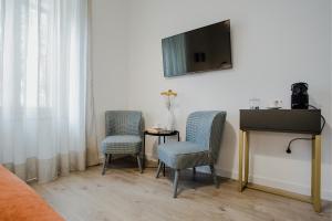 a room with two chairs and a table and a tv at Inn by the River in Omiš