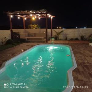 a swimming pool in a yard at night at Casa Esquina do Mar in São Francisco do Sul