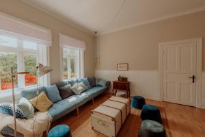 un soggiorno con divano blu e sedie di Landhaus Kurzenmoor - FeWo Sommerhaus, 100 qm 