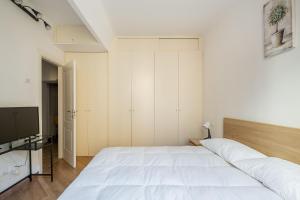 una camera con un grande letto bianco e una TV di Cozy central apartment by Wonderful Italy a Bologna