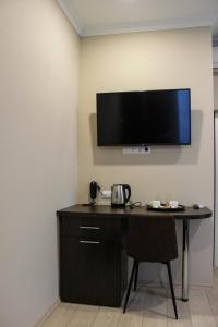 a room with a desk with a television on the wall at Rosemary Inn in Saransk