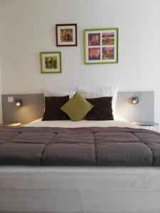 ラ・ロシェルにある33 Ter Bon pied à terreの壁に2枚の写真が飾られたベッドルームの大型ベッド1台