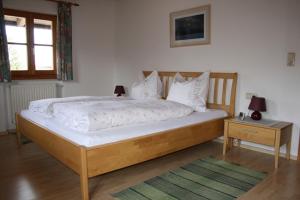 ein Schlafzimmer mit einem großen Bett mit weißer Bettwäsche und Kissen in der Unterkunft Zaissererhof in Brannenburg
