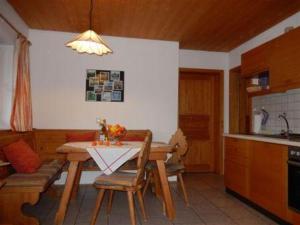 eine Küche mit einem Tisch und Stühlen im Zimmer in der Unterkunft Zaissererhof in Brannenburg
