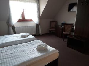 ein Hotelzimmer mit 2 Betten und einem Schreibtisch in der Unterkunft Gościniec nad Zalewem in Podgórzyn