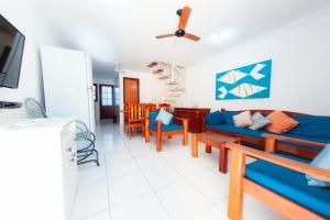 - un salon avec un canapé bleu et des chaises dans l'établissement Apartamento Condomínio Jerusalém, à Porto Seguro