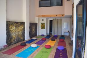 - une salle de yoga avec des tapis colorés au sol dans l'établissement La Grande Oasis - B&B et Spa, à Grazac