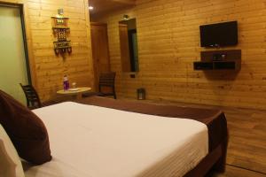 Un pat sau paturi într-o cameră la Oxygen Resorts Mahabaleshwar