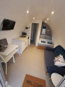 a living room with a couch and a bed in a room at Loch Ness Pods in Fort Augustus