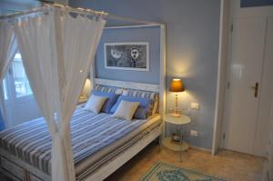 een slaapkamer met een wit hemelbed met blauwe kussens bij New Romantic in Cagliari