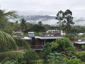 ein Haus inmitten eines Waldes mit Wolken in der Unterkunft Baan Boom Boxes Eco Friendly Resort in Mae Nam