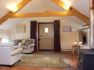 a living room with a couch and a chair at Crooke Barn in Tiverton