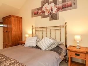 a bedroom with a bed with two pillows on it at Crooke Barn in Tiverton