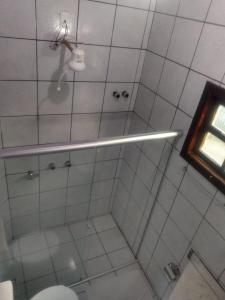 a bathroom with a shower with a toilet and a light at Pousada Portal do Sol in Itacaré