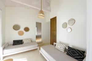 Duas camas num quarto com paredes brancas e espelhos em Karidi Beach Boutique Suites em Vourvourou