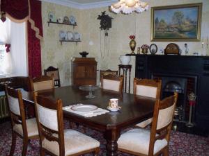 una sala da pranzo con tavolo e sedie in legno di Lisnafillan Lodge a Ballymena