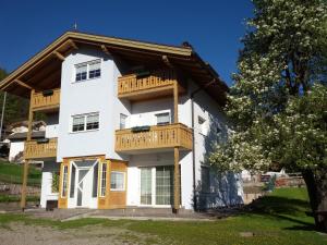 a white house with wooden balconies on it at Alla Fontana Termale in Carano