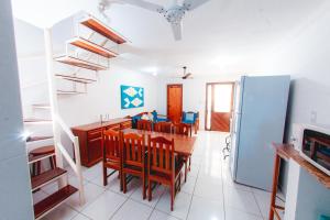 Il comprend une cuisine et une salle à manger avec une table et un réfrigérateur. dans l'établissement Apartamento Condomínio Jerusalém, à Porto Seguro