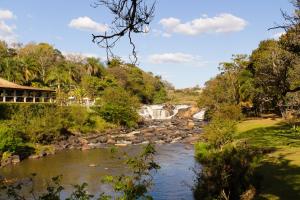 a river in front of a resort with a waterfall at Hotel Recanto da Cachoeira in Socorro