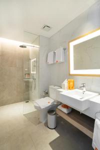uma casa de banho com um lavatório, um WC e um chuveiro em Harris Suites Puri Mansion em Jakarta