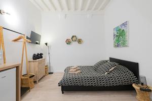 a bedroom with a bed in a room with white walls at Vence... un goût d'ailleurs in Vence