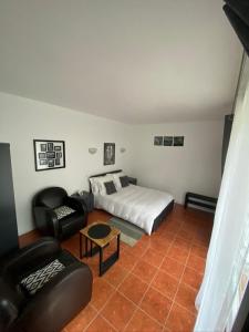- une chambre avec un lit, un canapé et une chaise dans l'établissement Appartement 2 pièces neuf et indépendant, à Jouy-en-Josas