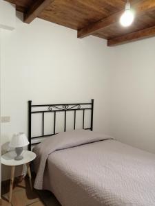 a bedroom with a bed and a white wall at Elisa affittacamere in Foligno