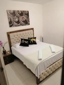 a bedroom with a bed with a love pillow on it at SAN JACINTO HOSTEL in Cartagena de Indias