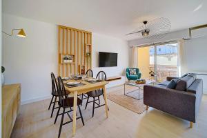 ein Wohnzimmer mit einem Tisch und einem Sofa in der Unterkunft IMMOGROOM- Renovated- Large terrace- AC- Shops- Parking in Cannes