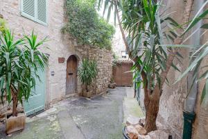 an alley with a building with a door and plants at Vence... un goût d'ailleurs in Vence