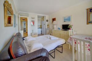 uma sala de estar com uma cama e um sofá em IMMOGROOM- Sea view - Center- AC- Front of the beaches em Cannes