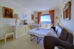 uma sala de estar com um sofá e uma cozinha com vista em IMMOGROOM- Sea view - Center- AC- Front of the beaches em Cannes