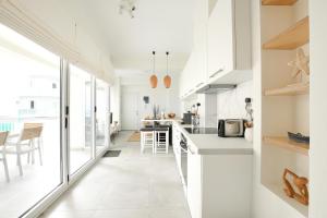 a kitchen with white cabinets and a large window at Ammos Suite in Hersonissos