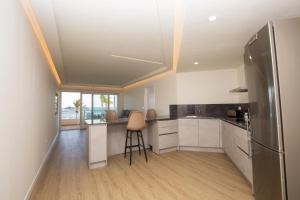 a kitchen with white cabinets and a stainless steel refrigerator at Luxury Ocean Beach Apartment in Altea