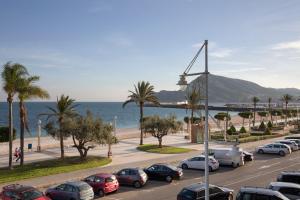 a parking lot with cars parked next to the ocean at Luxury Ocean Beach Apartment in Altea