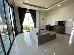 uma sala de estar com um sofá e uma televisão em Aownoi Bay Resort em Prachuap Khiri Khan