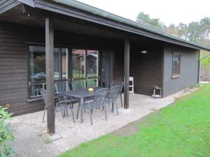 a patio with a table and chairs in front of a house at Erlengrund 20 in Isenbüttel