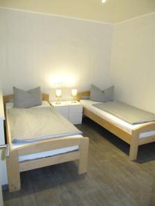 Dos camas en una habitación con dos lámparas. en Erlengrund 20, en Isenbüttel