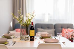 uma garrafa de vinho sentada numa mesa com copos em Apartment Poznan Park Cytadela by Renters em Poznań