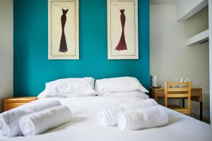 a white bed with three towels on top of it at The Lord Grenfell in Maidenhead