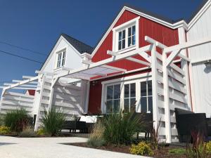 a red and white house with white trim at Mamma Mia Resort in Łukęcin